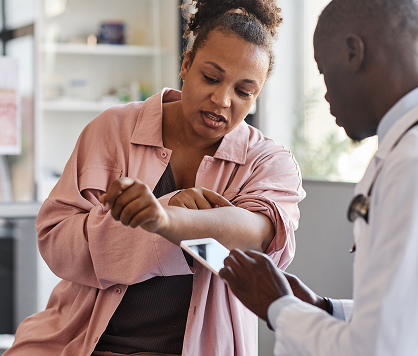 A doctor examining atopic dermatitis on a woman's arm